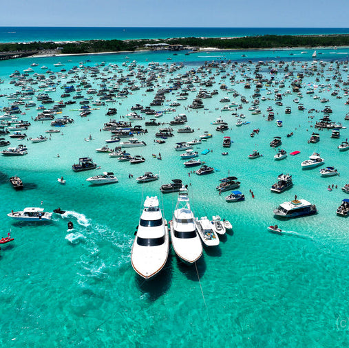 Aerial view of a marina filled with numerous boats in clear blue water.